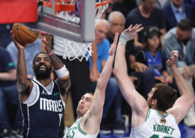 Kyrie Irving von den Dallas Mavericks mit einem Korbleger gegen zwei Gegenspieler von den Boston Celtics