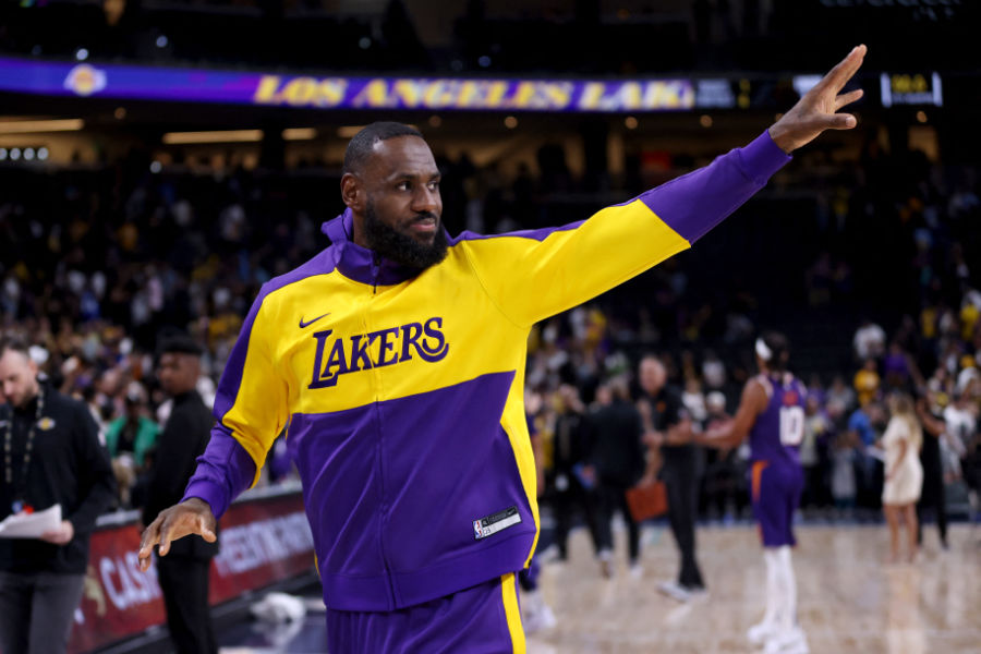 LeBron James trägt einen Lakers-Trainingsanzug und winkt den Fans zu